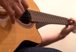 Un hombre tocando la guitarra en una clase del Estudio Samela de Educación Musical (ESSEM)