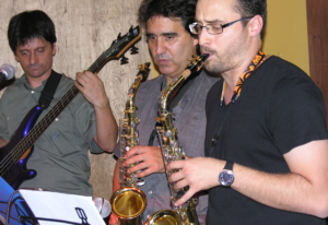 Dos hombres tocan el saxo mientras leen partituras en el Estudio Samela de Educación Musical (ESSEM)